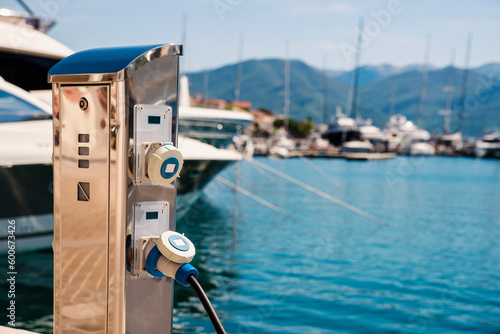 Charging station for boats. Electric sockets for charging ships in the harbor on a pier near the sea coast. Charging the yacht from the power station in the marina. Smart marine pedestal. photo