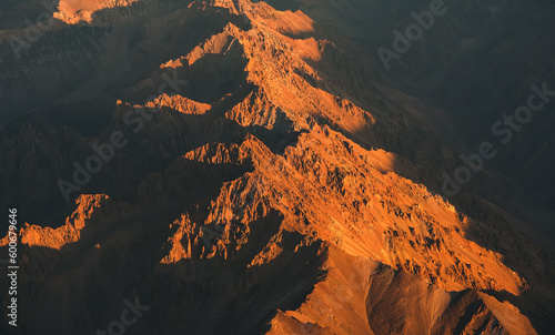 Fototapeta Naklejka Na Ścianę i Meble -  Andes Mountains at sunset. Aerial photo with the amazing sunset landscape over the tallest peaks in South America, part of Andres Mountains.