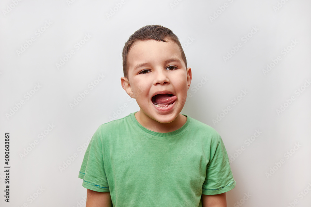 A handsome, cheerful guy poses emotionally for the camera, showing his tongue. A handsome, cheerful guy poses emotionally for the camera, showing his tongue.