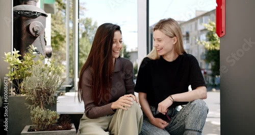 Wallpaper Mural Young women with coffee chatting on street. Handheld shot of young girlfriends with coffee to go talking and laughing while spending sunny weekend day on city street together Torontodigital.ca