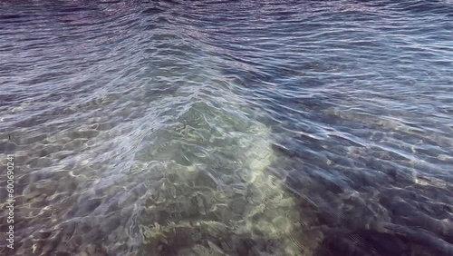Small sea wave slow motion. Beautiful waves on shore. Ripples on the water,  yellow sea color and Mixing sand. Seamless loop
