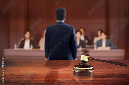 Judge's hammer symbolizes the judgment on the judicial wooden table in courtroom front of the lawyer talk to jury on courtroom