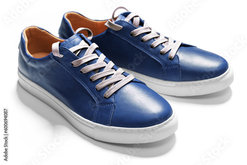 Blue leather sneakers isolated on white background with shadow. Angle view. Selective focus.