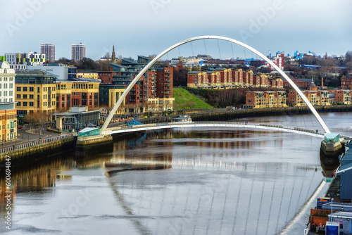 Gateshead Millennium Bridge crossing River Tyne in Gateshead, with a view of Newcastle upon Tyne, UK photo