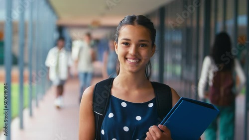 Portrait of female high school student walking outside classrooms with backpack and files - shot in slow motion