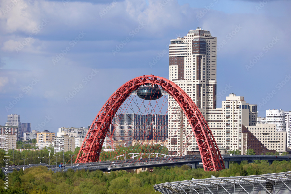 View of red cable-stayed Zhivopisny bridge in Moscow and modern residential buildings View of red cable-stayed Zhivopisny bridge in Moscow and modern residential buildings