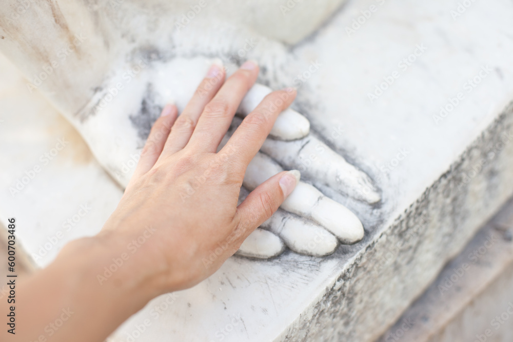 hand touching stone  sculpture's hand. Dating emotionally unavailable partners metaphor. Grieving breakup or love loss. Relationship trauma. - obrazy, fototapety, plakaty 