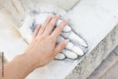 hand touching stone sculpture's hand. Dating emotionally unavailable partners metaphor. Grieving breakup or love loss. Relationship trauma.