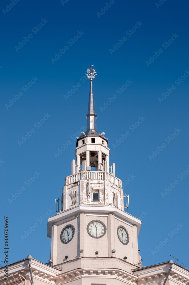 Voronezh, Russia, November 30, 2022: The spire with the clock of the administrative building against the blue sky