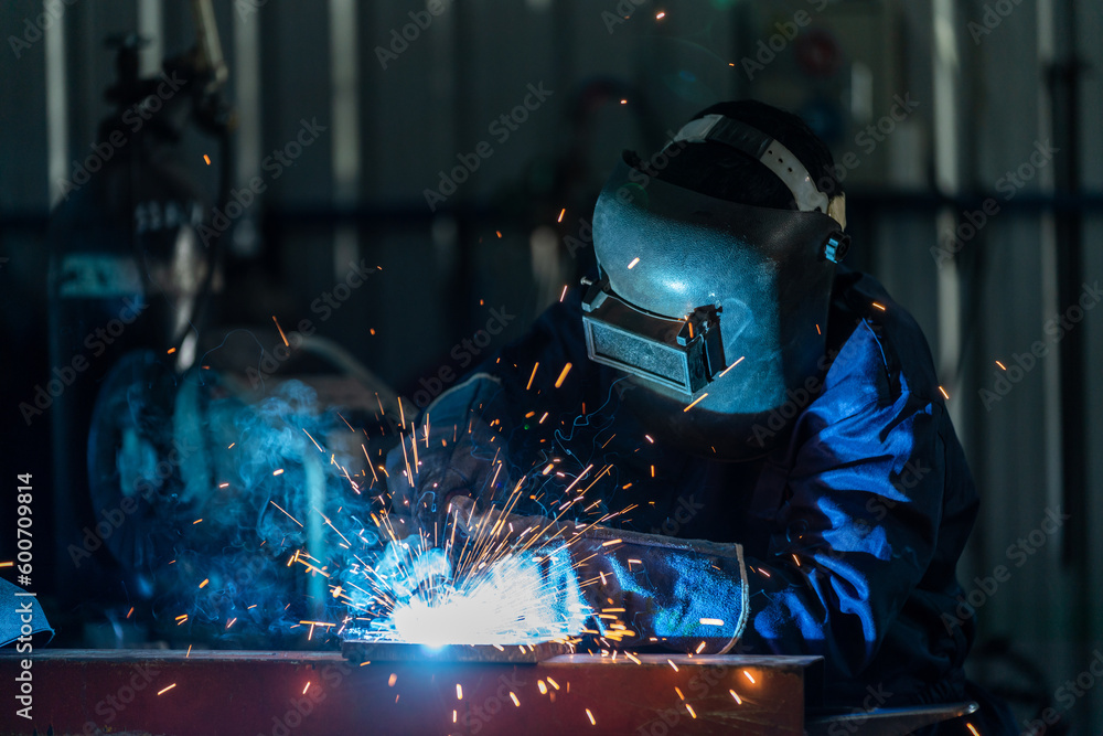 © tong2530 - A workers wearing industrial uniforms and welded iron mask at steel welding plants, Industrial safety first concept. © tong2530 - A workers wearing industrial uniforms and welded iron mask at steel welding plants, Industrial safety first concept.