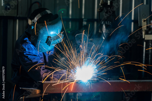 A Workers are welding steel at a heavy industry factory. Industrial safety first concept.