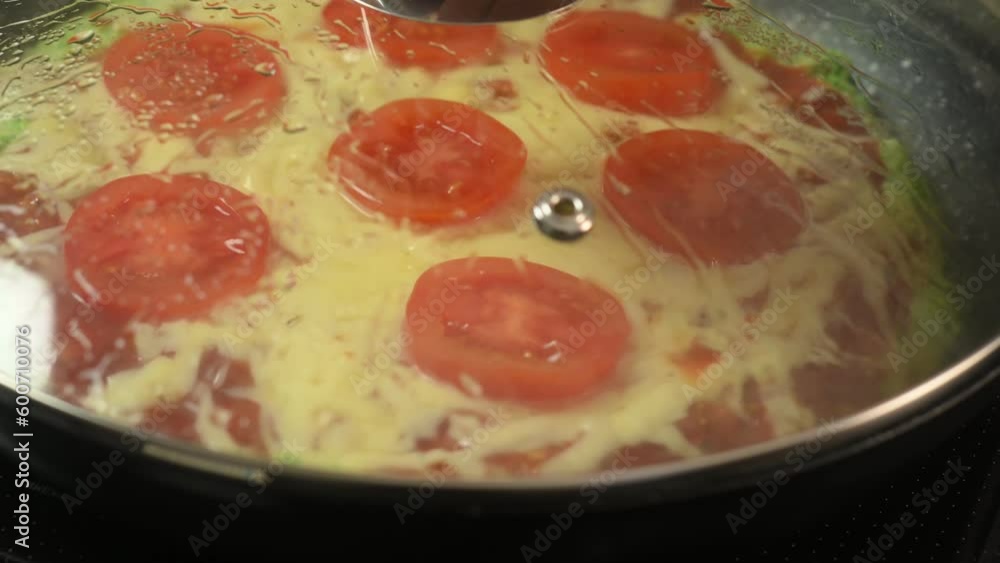 Pizza from broccoli is frying on the pan. Cheese and tomatoes. Pizza from broccoli is frying on the pan. Cheese and tomatoes.