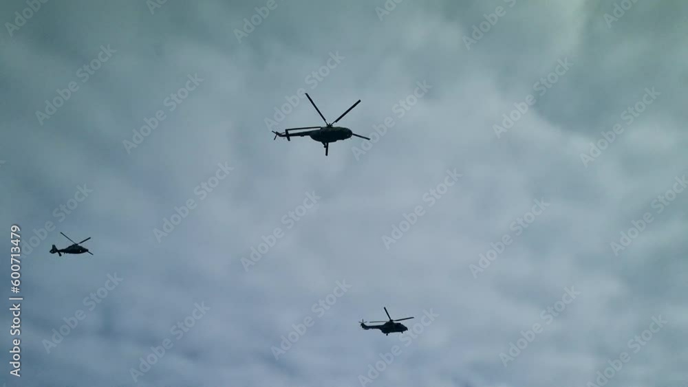 Four military helicopters fly together in a cloudy sky Four military helicopters fly together in a cloudy sky