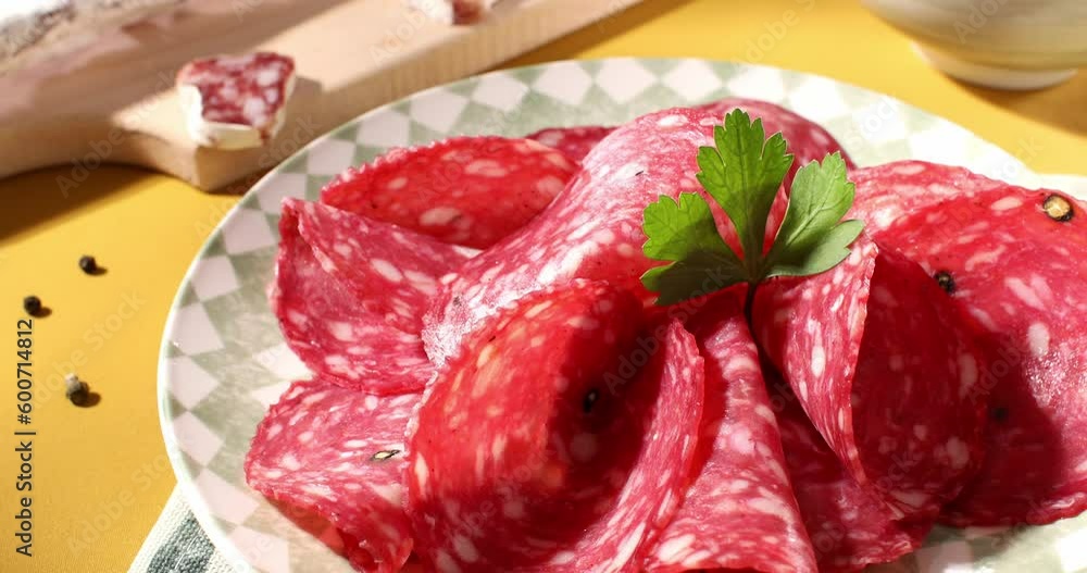 slices sausage salchichon on a plate. salami on a cutting board. cold cuts with bread and tomatoes. traditional spanish and italian sausages. meat delicacies antipasto on the table. slices sausage salchichon on a plate. salami on a cutting board. cold cuts with bread and tomatoes. traditional spanish and italian sausages. meat delicacies antipasto on the table.