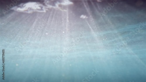Sunlight god rays shining through ocean surface. Turquoise sea color View from underwater. Seamless loop slow motion 