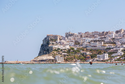 A sea beach with people who rest in the summer on it and buildings of Peschici  Puglia