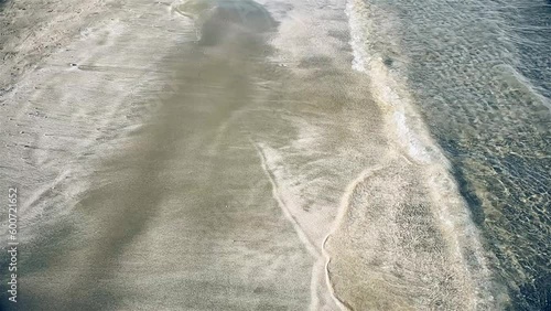 Beach sand shadow walking. Slow motion. Holding hands. Summer time, holidays vibes. Abstract sand of beach.  Soft wave background  