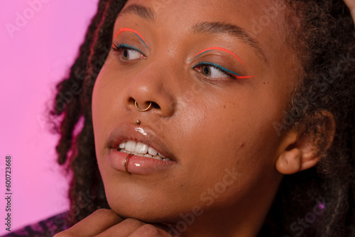 Fotografie Young woman wearing pink eyeliner and piercings