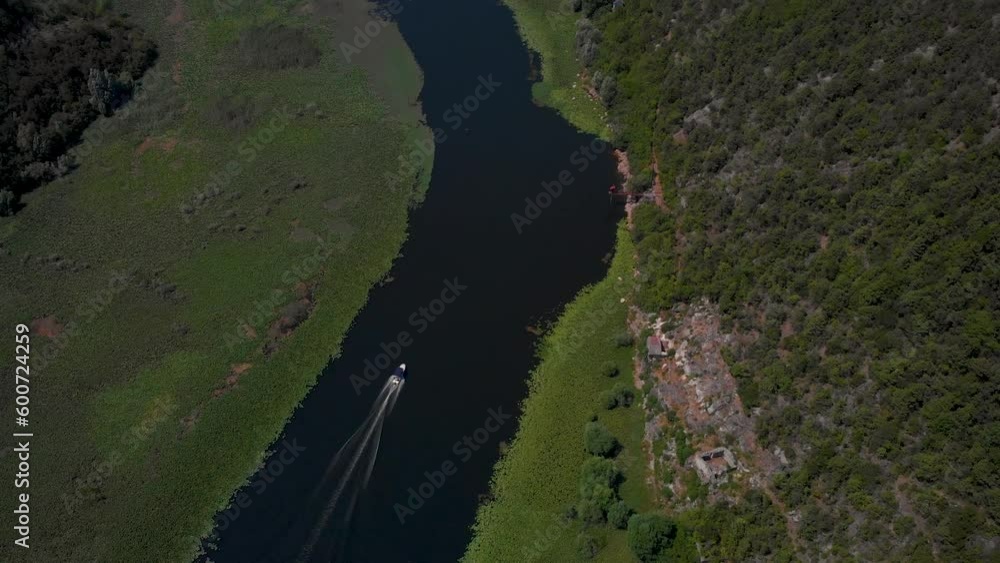 Tourist Boat Cruising On The River At Pavlova Strana Viewpoint In Lake Skadar National Park, Montenegro. Aerial Drone Shot Tourist Boat Cruising On The River At Pavlova Strana Viewpoint In Lake Skadar National Park, Montenegro. Aerial Drone Shot