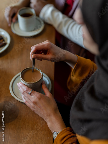 Woman stirring tea with milk