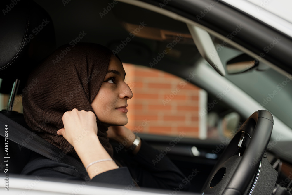 Young woman wearing hijab driving car Young woman wearing hijab driving car