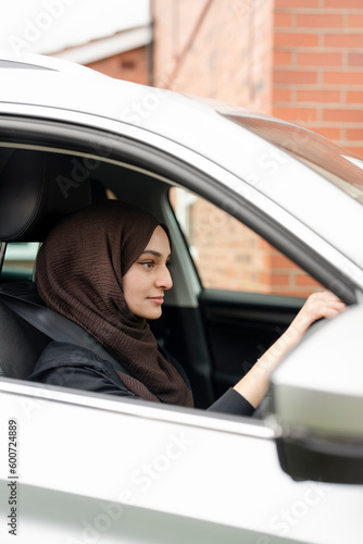 Young woman wearing hijab driving car © Cultura Creative