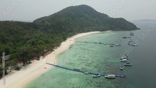 Beautiful Kahung Beach of Coral Island near Phuket, Thailand. 4k60 aerial view of island landscape, beach, floating docks and boats on clear water of Andaman Sea. photo