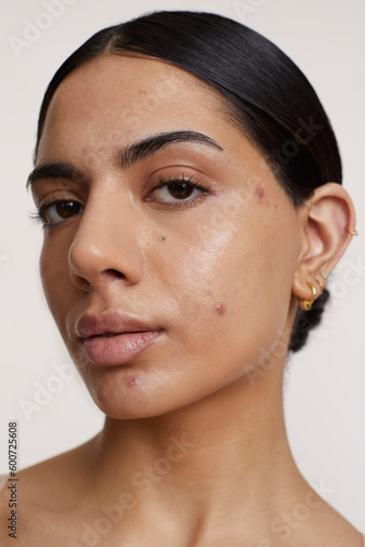 Portrait of young woman looking at camera against white background photo