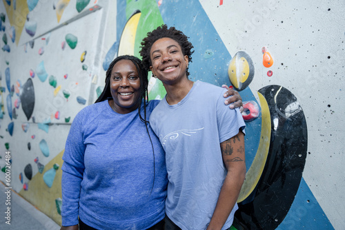 Portrait of mother and daughter standing in front of climbing wall