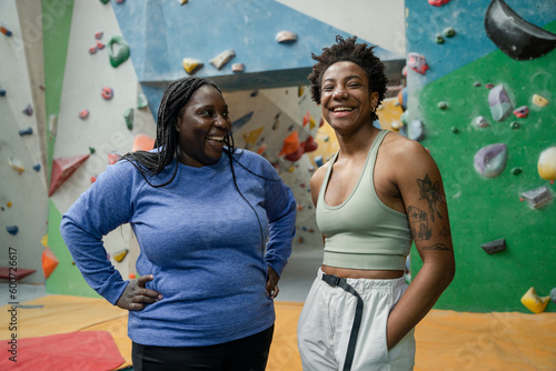 Portrait of mother and daughter standing in front of climbing wall © Cultura Creative
