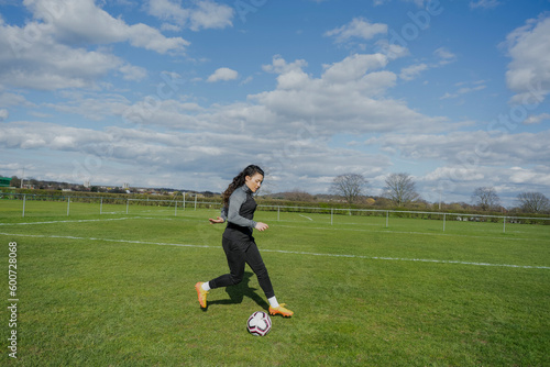 Young woman playing soccer outdoors