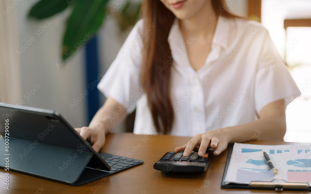 Women are using calculators to calculate office income. Women are using calculators to calculate office income.