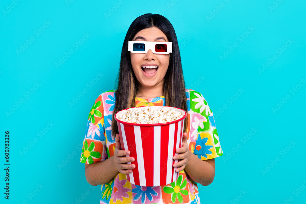 Photo of impressed funky woman dressed flower print t-shirt exciting watching vr film isolated blue color background