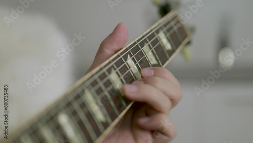 Man playing an electric guitar doing a scale with his left hand on camera