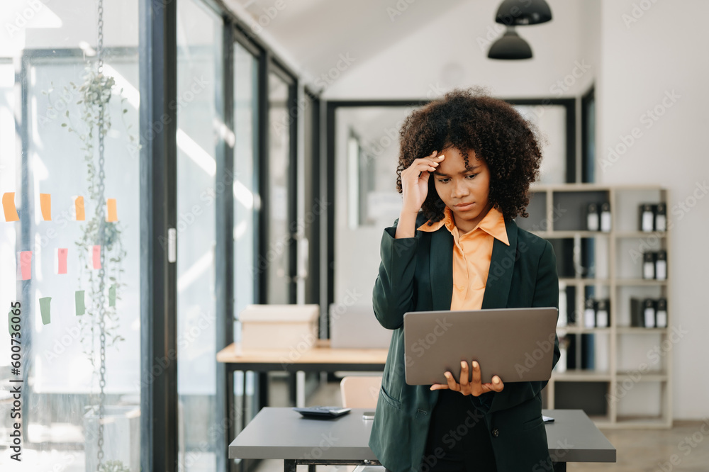 Obraz premium African business woman is stressed, bored, and overthinking from working on a tablet at the office.