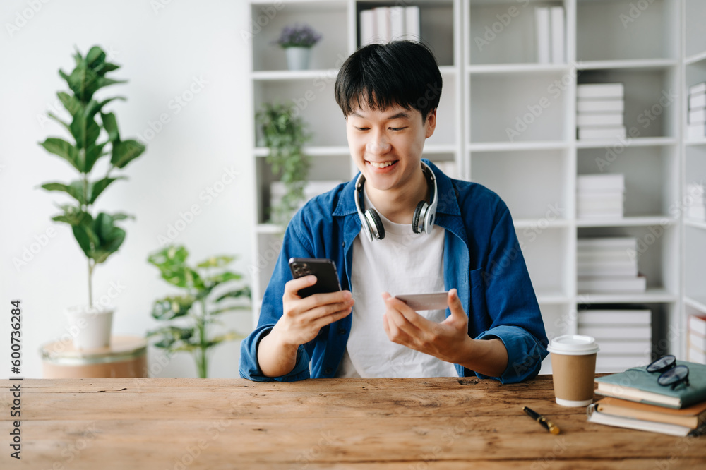 Man using smart phone for mobile payments online shopping,omni channel,sitting on table Man using smart phone for mobile payments online shopping,omni channel,sitting on table