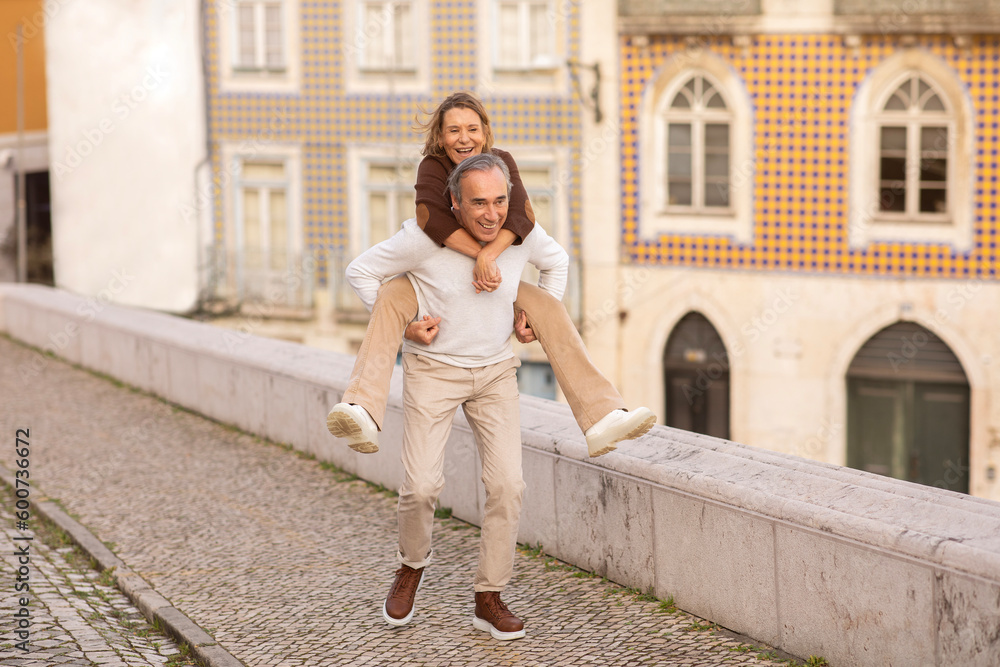 Mature Spouses Having Fun In Lisbon, Husband Carrying Wife Piggyback