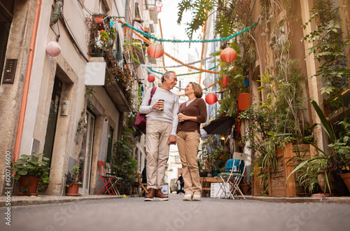 Senior Couple Strolling Through Lisbon's Streets Holding Coffee Cups Outdoor