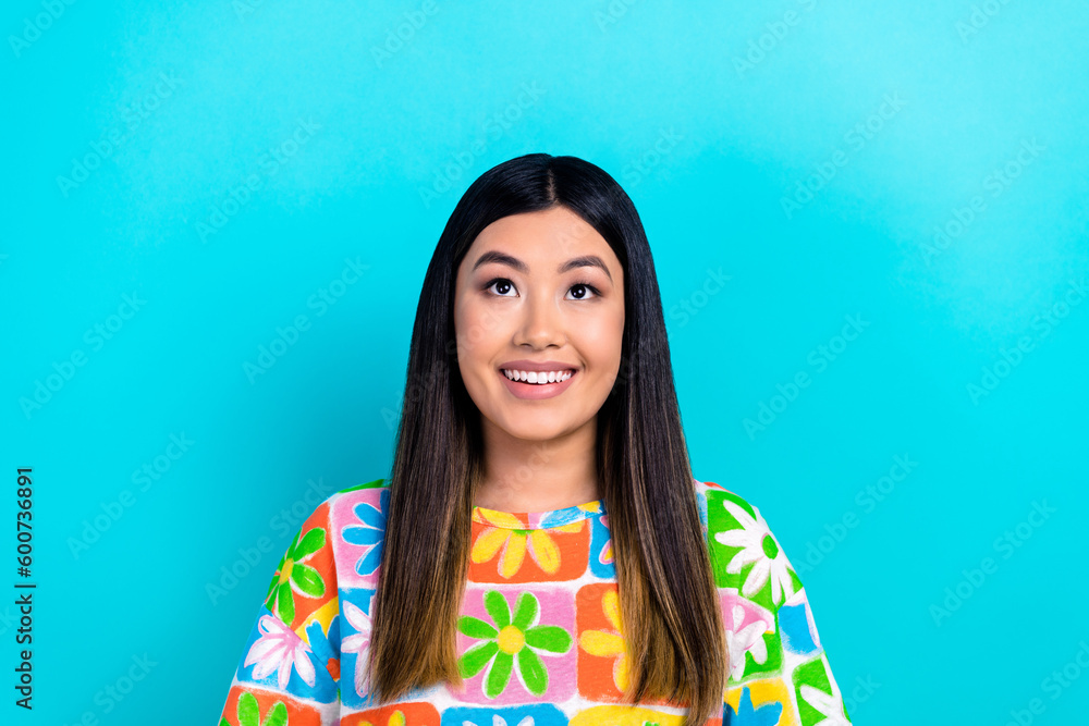 Photo of adorable cheerful girl beaming smile look up empty space isolated on blue color background Photo of adorable cheerful girl beaming smile look up empty space isolated on blue color background