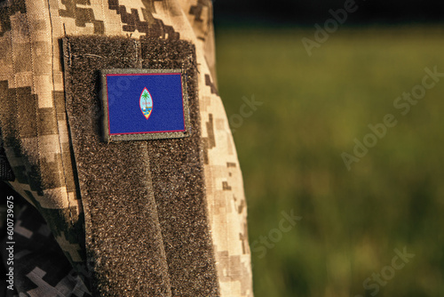 Close up millitary woman or man shoulder arm sleeve with Guam flag patch. Troops army, soldier camouflage uniform. Armed Forces, empty copy space for text
