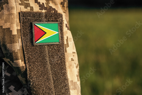 Close up millitary woman or man shoulder arm sleeve with Guyana flag patch. Troops army, soldier camouflage uniform. Armed Forces, empty copy space for text 