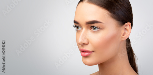 Young Lady With Perfect Skin Looking Aside, Gray Background