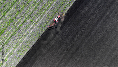 Farmer ploughing the fields in spring at Uffelter es Drenthe Netherlands with tractor. Aerial view.