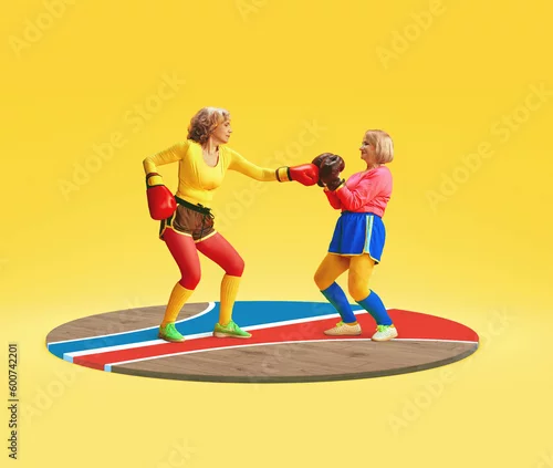 Obraz Two senior, middle-aged women in colorful uniform training, boxing against yellow studio background. Concept of sportive lifestyle, health care, action and motion, well-being. Copy space for ad