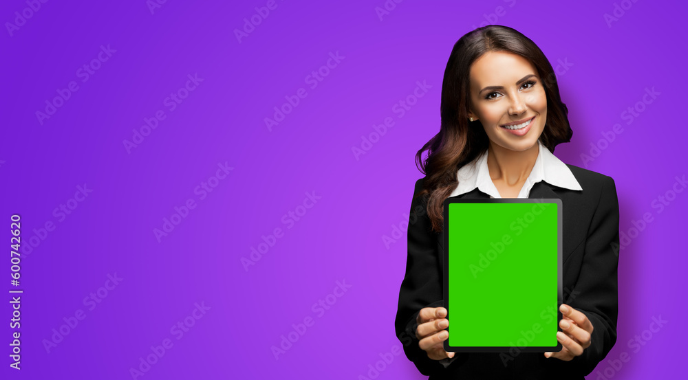Portrait of happy smiling brunette businesswoman showing tablet pc, touchpad, with green chroma key screen, on violet purple background. Cheerful beautiful business woman at office. Portrait of happy smiling brunette businesswoman showing tablet pc, touchpad, with green chroma key screen, on violet purple background. Cheerful beautiful business woman at office.