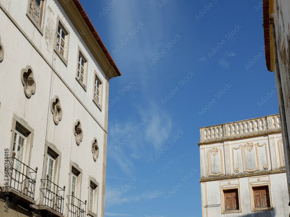 Old house shabby facades with windows against blue clear evening sky in Elvas, Portugal
