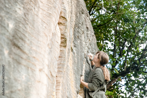young active teen girl doing outdoor rock climbing bouldering on natural cliff. High quality photo © Alena Yakusheva