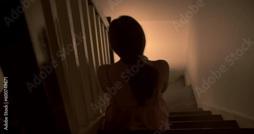 A lonely woman is sitting on the stairs at night . This concept use for symptoms of stress, major depressive disorder (MDD), psychotic symptoms.  photo
