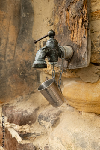 an old faucet on a stone wall