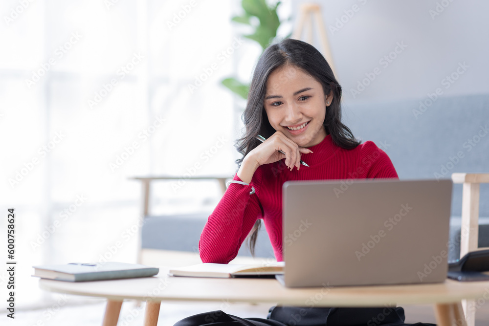Beautiful Young asian woman at home sitting on the sofa while using laptop and headphone at home Beautiful Young asian woman at home sitting on the sofa while using laptop and headphone at home